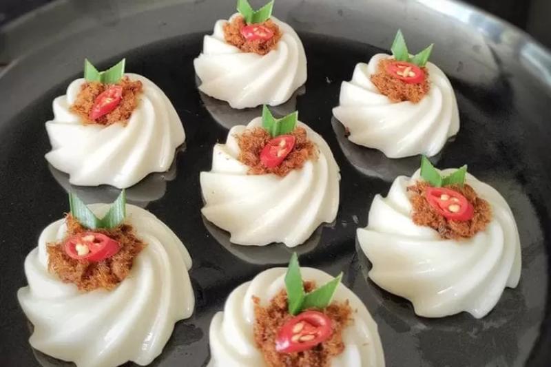Kue talam abon disajikan dengan abon daging gurih dan renyah.
